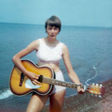Robin playing guitar on the beach